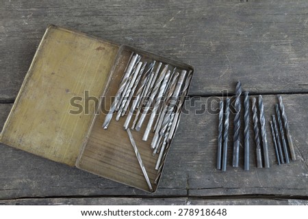 Set of drill bits on an old wood background
