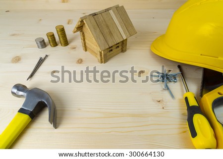 Planning a project of a home. Set of tools, money and toy home model with excessive space