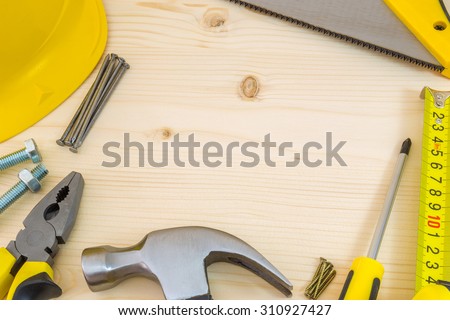 Project planning in carpentry and woodwork industry. Notebook and assorted woodwork tools on pinewood workshop table.