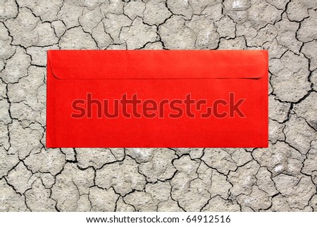 red envelope on dry soil with crack background