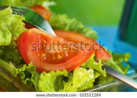 Fresh salad of lettuce and tomato (Selective Focus, Focus on the seeds of the tomato slice in the front)