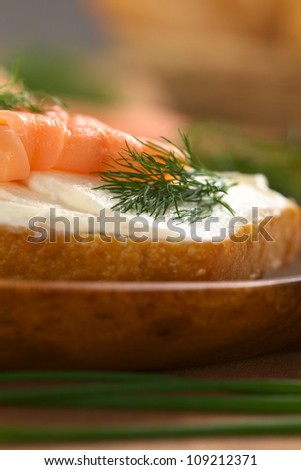 Canape of smoked salmon and cream cheese on wholewheat bun garnished with dill (Selective Focus, Focus on the front of the dill)