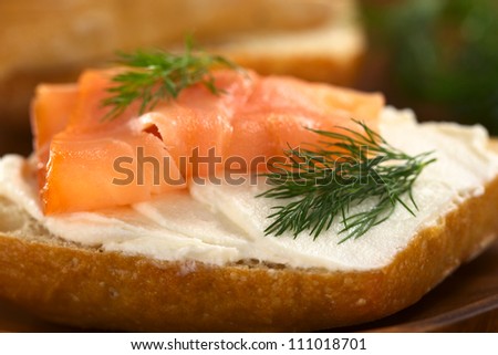 Canape of smoked salmon and cream cheese on wholewheat bun garnished with dill (Selective Focus, Focus on the front of the dill on the right)