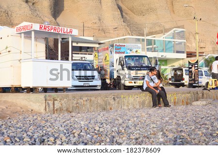 LIMA, PERU - APRIL 2, 2012: Unidentified young couple sitting on April 2, 2012 on the coast of Miraflores, Lima, Peru. Inhabitants of Lima like going to the coast for resting, walking, swimming.