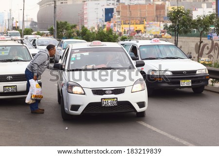 LIMA, PERU - JULY 21, 2013: Unidentified man asking a taxi for the fare on Av. Paseo de la Republica in the city center on July 21, 2013 in Lima, Peru. In Lima, taxi fares are agreed upon beforehand.