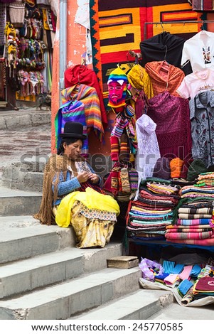 LA PAZ, BOLIVIA - NOVEMBER 10, 2014: Unidentified woman doing crochet sitting on stairs beside small street stand on corner of the streets Sagarnaga and Linares on November 10, 2014 in La Paz, Bolivia