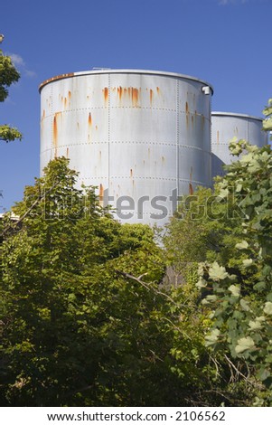 Rust marks on a grey industrial tank against a blue sky