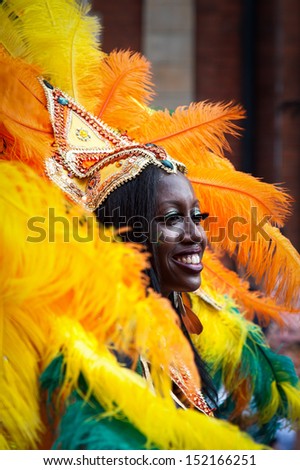 LONDON, ENGLAND - AUGUST 26: A street dancer wearing a feathered headdress and costume at Notting Hill Carnival on August 26, 2013 in London