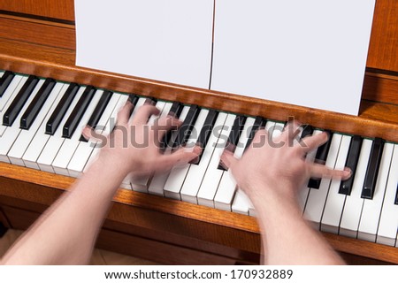 Piano player showing movement of the hands with blank music sheets