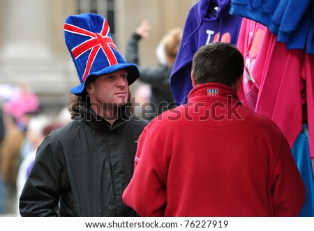 LONDON - APRIL 29: An unidentified street seller offers flags for sale at Trafalgar Square in celebration of the wedding of Prince William and Catherine Middleton on April 29 2011 in London, England.