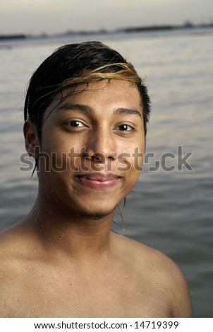 stock photo Smiling wet asian man at seaside