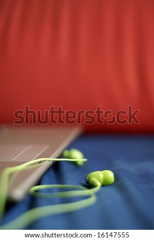 Green earphones and laptop closeup in vertical format