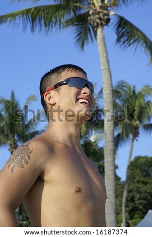stock photo Happy asian man at beach with sunglasses and tattoo of chinese