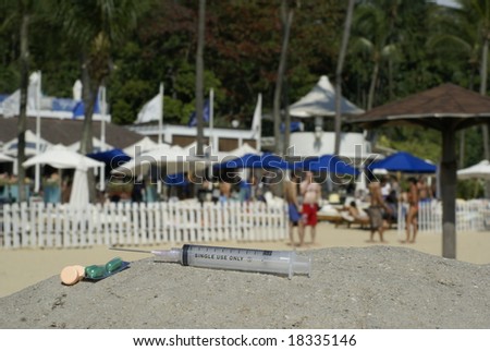 Pills and syringe in front of beach party scene