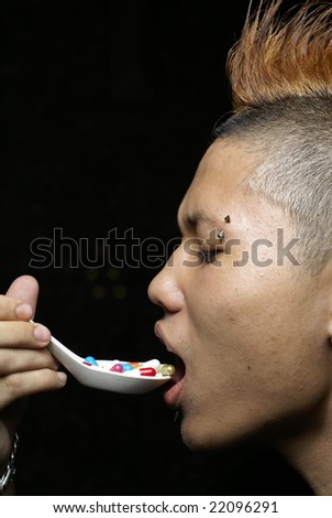 Punk asian man eat pills