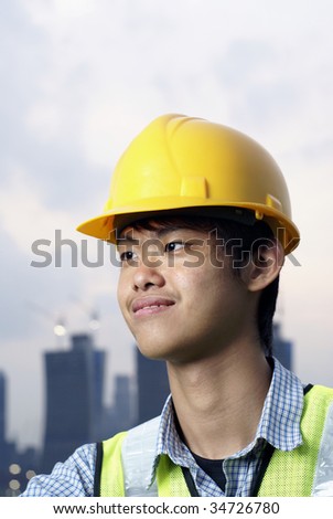 Young asian construction engineer smiling with yellow hardhat, vertical format