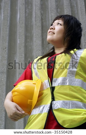 Asian female construction contractor lady looking up with concrete wall