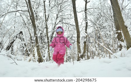 Little winter girl in fairy ice forest running
