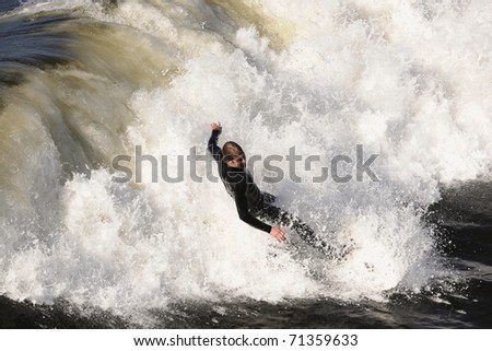 Surfer gets up on a wave. The wave twists with foam and splashes.