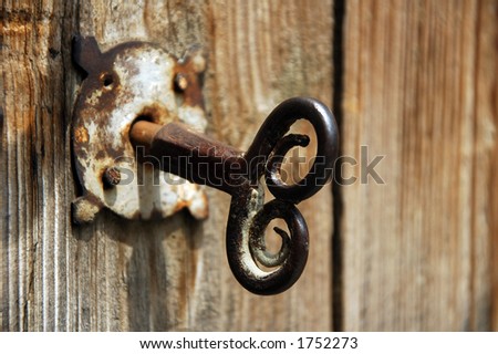 Old house key in wooden doors.