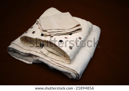 Beige fresh clean towels on a brown cover