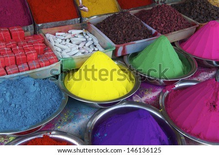 Colorful piles of Indian bindi powder dye at outdoor market in India blue, yellow, green, pink, and purple