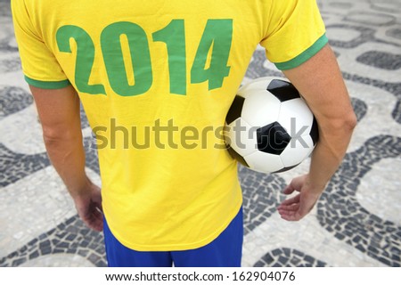 Brazilian soccer player holding football wears 2014 shirt in Brazil colors Rio de Janeiro