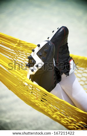 Football boots close-up of soccer player relaxing in beach hammock