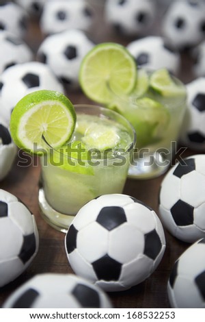 Two authentic fresh lime caipirinhas with soccer footballs Brazilian culture