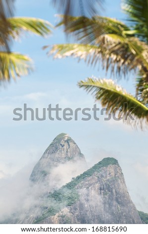 Rio de Janeiro Brazil with palm trees in front of misty view of Two Brothers Dois Irmaos Mountain