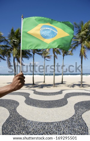 Brazilian hand waving Brazilian flag at Copacabana beach Rio de Janeiro