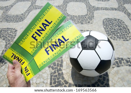 Fan holds two tickets to the football match above soccer ball in Rio de Janeiro Brazil