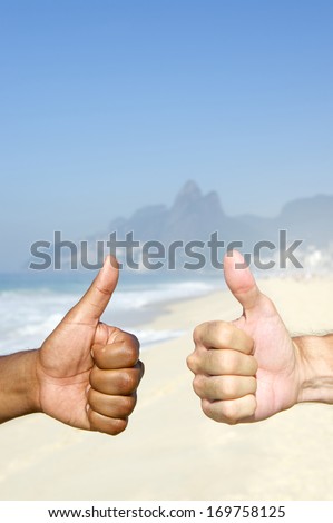 Brazilian diversity two interracial Carioca thumbs up on Ipanema Beach Rio de Janeiro Brazil