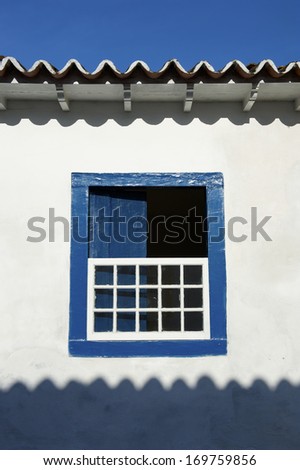 Brazilian colonial architecture simple open window blue frame on white stucco wall Paraty Brazil