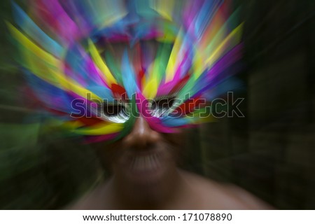 Brazil Carnival scene features smiling Brazilian man in colorful mask in jungle