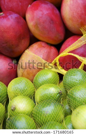Fresh red mangoes and shiny green limes at outdoor Brazilian tropical farmers market in Rio de Janeiro Brazil