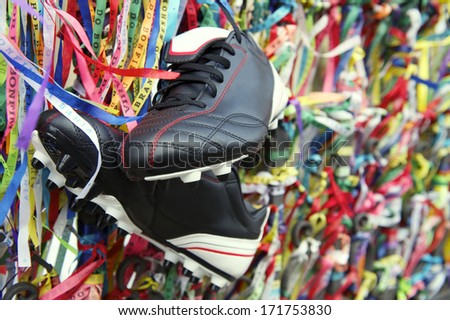 Football boots soccer cleats hanging with Brazilian wish ribbons at the Bonfim church in Salvador Bahia Brazil