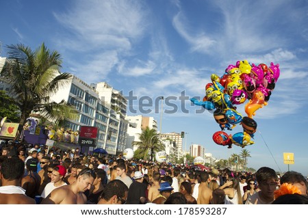 RIO DE JANEIRO, BRAZIL - FEBRUARY 22, 2014: Balloons float over crowds celebrating carnival in a bloco street party at Ipanema Beach.