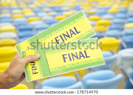 Soccer fan holding two Brazil final tickets in front of empty stadium seats