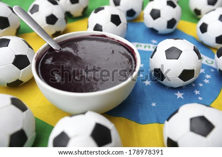 Brazilian flag makes a table mat under bowl of acai with soccer ball footballs