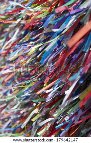 Colorful religious Brazilian wish ribbons Fita do Bonfim tied on church fence in Salvador Brazil