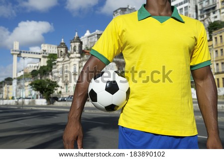 Brazilian soccer player holding football wearing shirt in Brazil colors Salvador