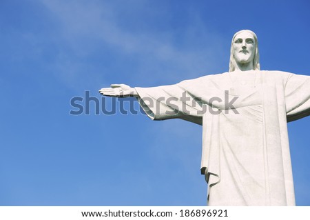 RIO DE JANEIRO, BRAZIL - OCTOBER 20, 2013: Statue of Christ the Redeemer at Corcovado stands in bright sun against clear blue sky.
