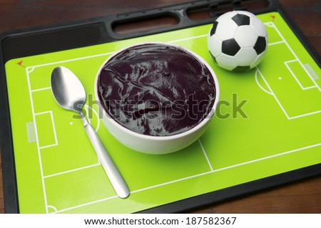 Bowl of acai sitting on Brazilian football tactics board with soccer ball