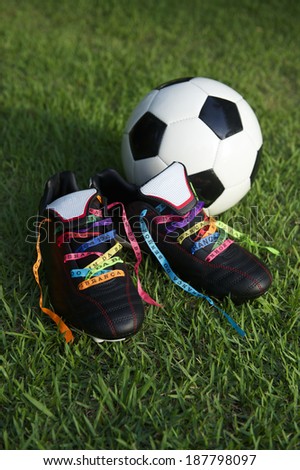 Good luck soccer football boots soccer cleats laced with Brazilian wish ribbons on green grass football pitch
