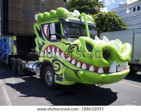 SALVADOR, BRAZIL - FEBRUARY 9, 2013: Giant green dragon trio electrico carnival music truck stands in the queue on the afternoon Barra Ondina circuit.