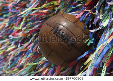 Vintage brown football soccer ball at wall of Brazilian wish ribbons at the Bonfim church in Salvador Bahia Brazil