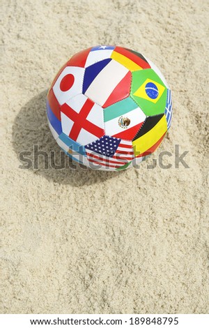 International country flag ball in textured sunny sand on the beach