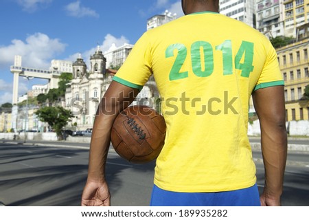 Brazilian soccer player holding football wearing 2014 shirt in Brazil colors Salvador Bahia