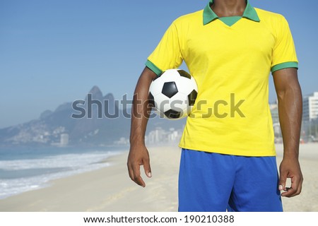 Brazilian football player in Brazil colors holding soccer ball Ipanema Beach Rio de Janeiro